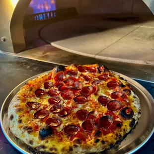 a pizza being cooked in a pizza oven