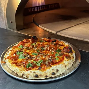 a pizza being cooked in a brick oven