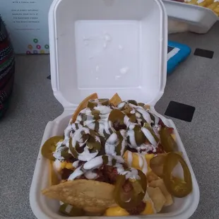 Little D Nachos. Media crema, Nacho cheese, Jalapeños, Alpastor meat, and Fries.