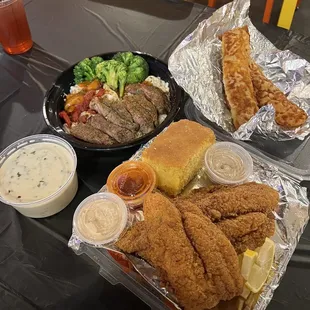 a meal of fried fish, breaded breaded rolls, and a salad