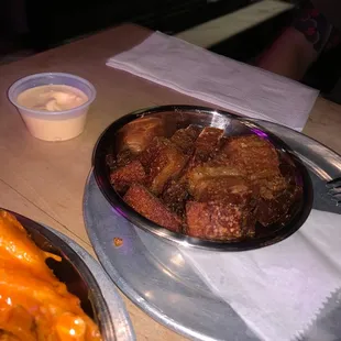 a plate of meat and a bowl of sauce