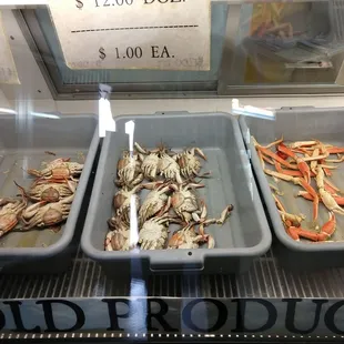 three trays of crabs in a display case