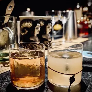 two glasses of alcohol on a table