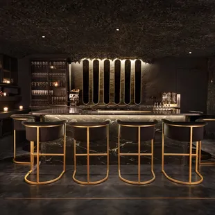 a bar with gold bars and stools