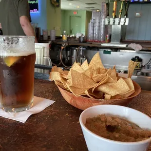 a bowl of chips and a glass of beer