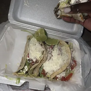 a person taking a slice of a taco
