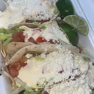 three tacos in a styrofoam container