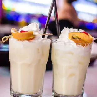 two glasses of ice cream with fruit garnish