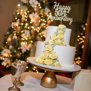 a white wedding cake with yellow roses