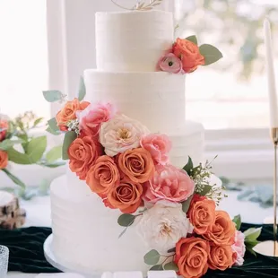 a white wedding cake with fresh flowers