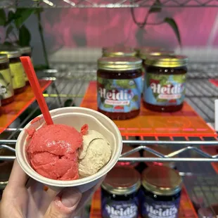 a hand holding a bowl of ice cream