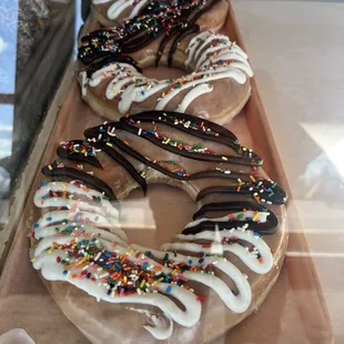 a row of doughnuts with white icing and sprinkles
