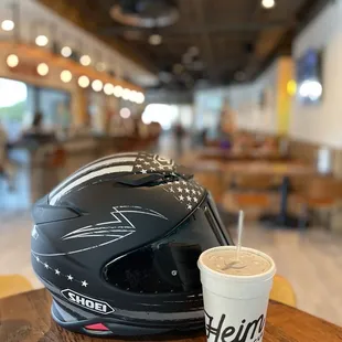 a helmet and a drink on a table