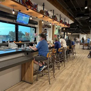 Bar area with lots of seating and multiple televisions playing assorted games.