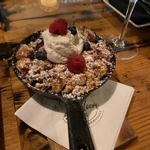 a pancake with berries and whipped cream