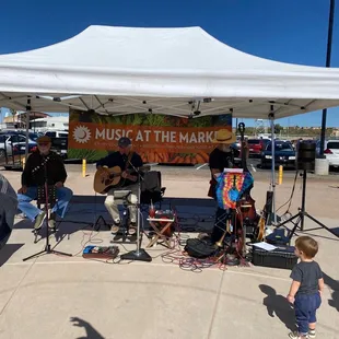 a group of people playing music under a tent