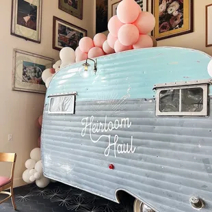 a vintage camper with balloons on top