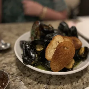 a plate of mussels and bread