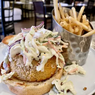 a chicken burger with coleslaw and french fries