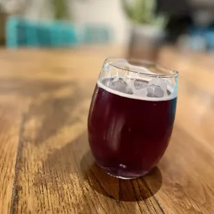 a glass of beer on a wooden table