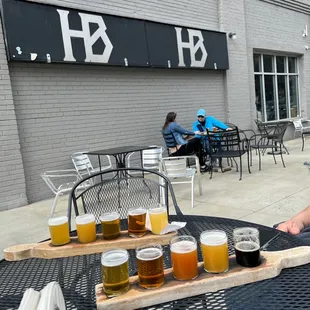 a man sitting at a table with a tray of beers