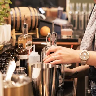a woman pouring a drink at a bar