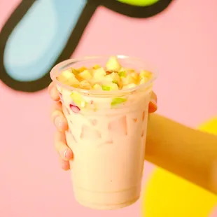 a hand holding a cup of fruity drink