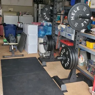 Squat rack, barbell, plates, and mats