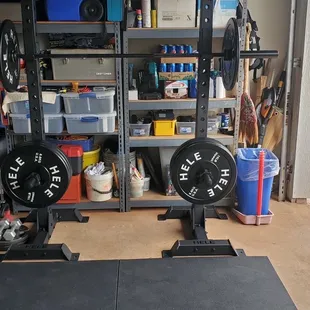 Squat rack, barbell, plates, and mats
