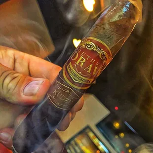 a hand holding a cigar