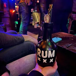 a person holding a rum bottle