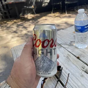 a person holding a can of boo