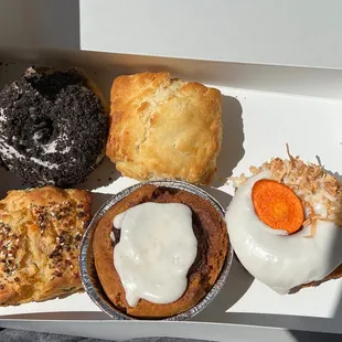 Clockwise beginning top left: cookies and cream donut, buttermilk biscuit, carrot cake donut, vegan cinnamon roll, scallion biscuit