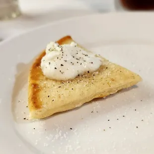 Small piece of pita bread with zatziki and pepper