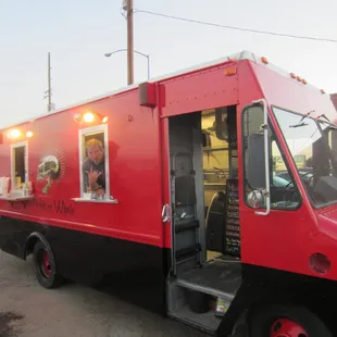 a red food truck parked in a parking lot