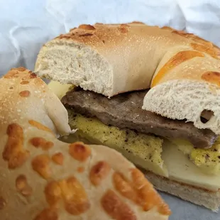 a breakfast sandwich with cheese, egg, and sausage