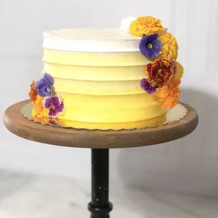 a yellow cake with flowers on top