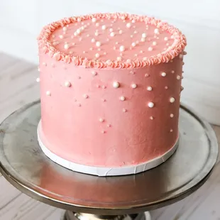 a pink cake on a cake stand
