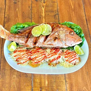 Fried Red Snapper served served with chopped fried green plantains and raw salad.