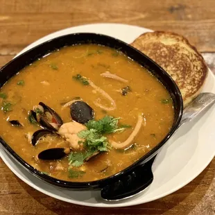 a bowl of soup with bread on the side