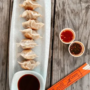 a plate of dumplings with dipping sauce