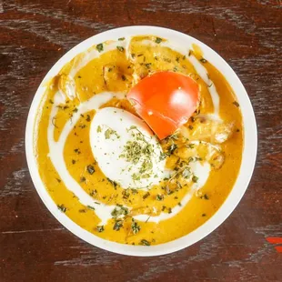 a bowl of soup with an egg on top