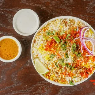 a plate of birya rice with a side of dipping sauce