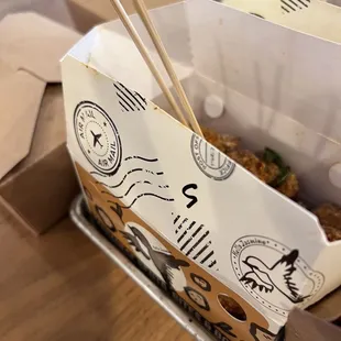 a take out box with chopsticks