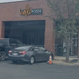 cars parked in front of a pizza place