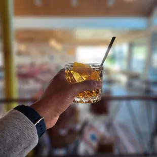 a person holding a glass of alcohol