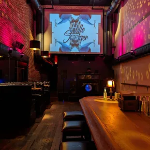 a bar with a large screen in the background