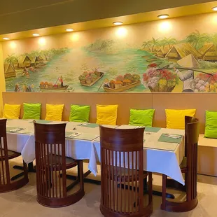 a dining room with a mural of boats on the wall