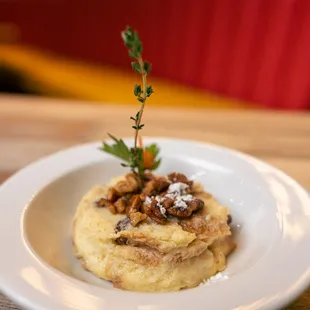 a plate of mashed potatoes with a sprig of thyme
