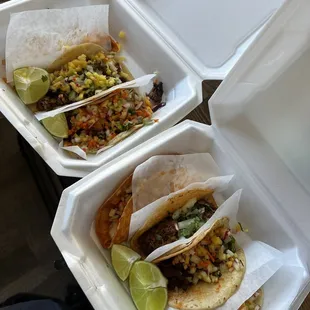 two tacoss in a styrofoam container